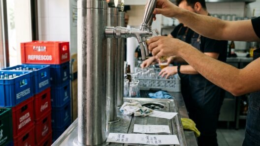 Grifos de cerveza y botellas de refresco alineados en la barra de un local de restauración organizada durante el servicio
